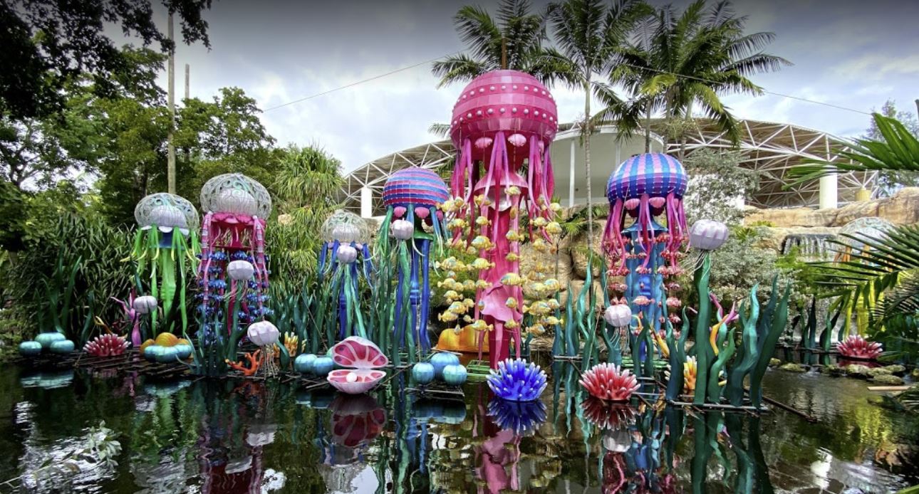 Colorful Chinese lanterns in the shape of sea life rise above a natural fish habitat at an eco-park and animal sanctuary and theme park in Miami during a festival.